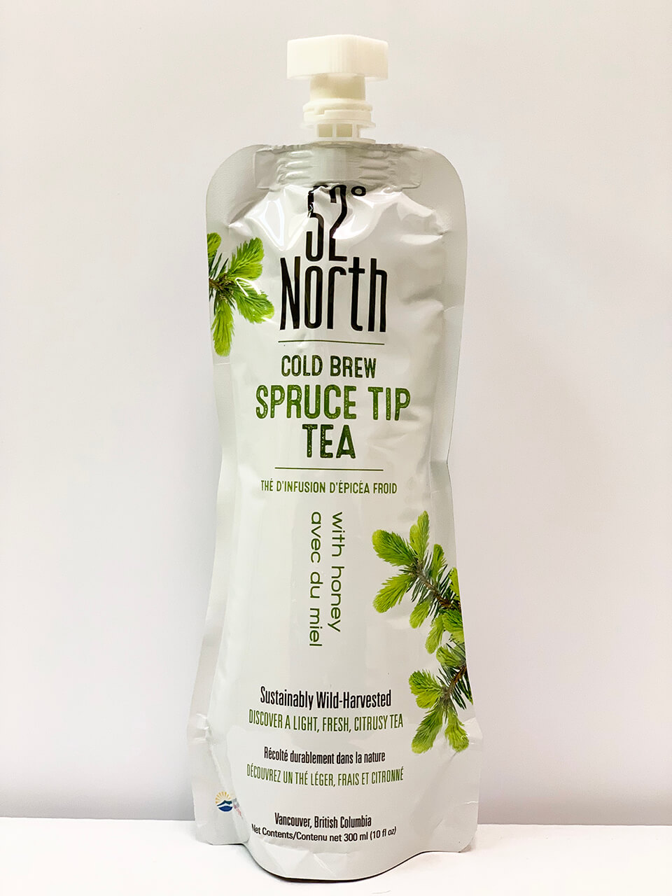 Tetra bag with twist cap and Fifty-Two Degrees North label reading "Spruce Tip Tea".