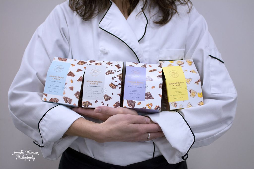 Chef holding a variety of four Fraser Valley Gourmet packages.