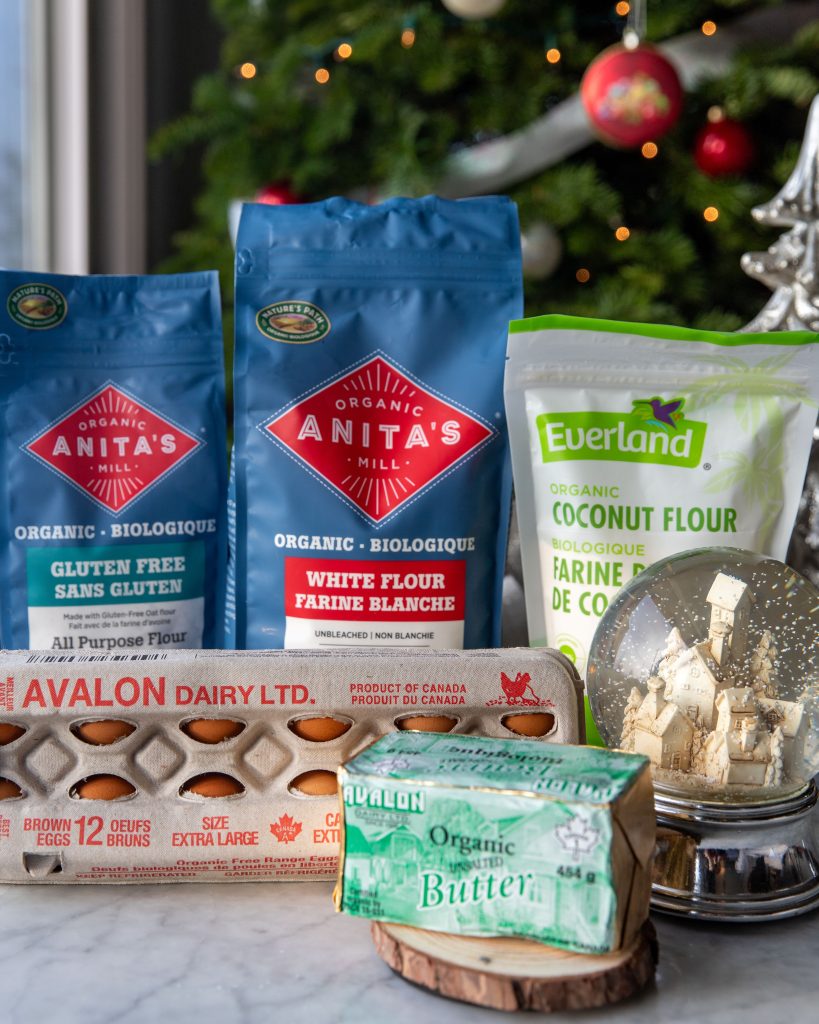 Made-in-B.C. ingredients for Holiday sugar cookies including Anita's Organic Mill flour and gluten-free flour, Everland Foods coconut flour, Avalon Dairy butter and eggs, lined up on a counter. 