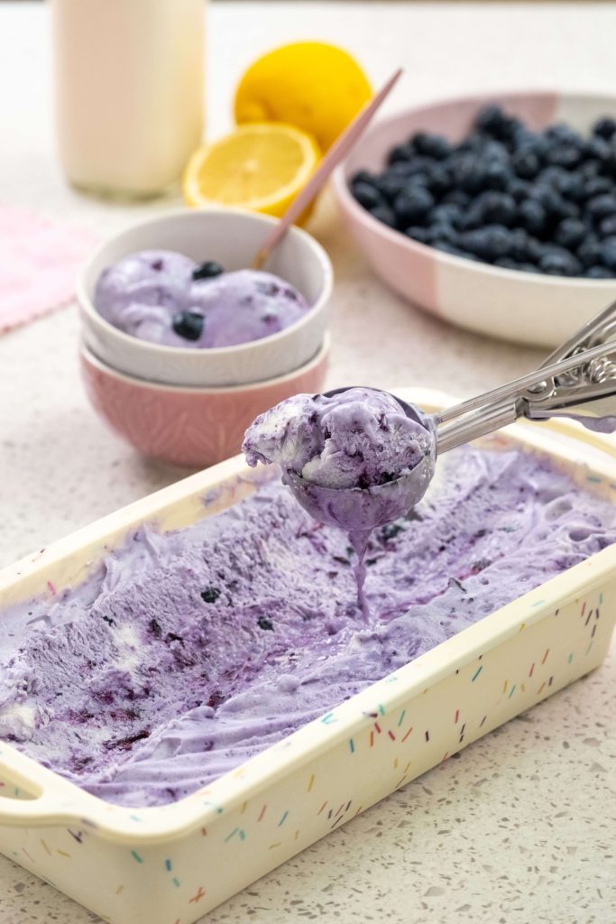 B.C. blueberries in a bowl in the background and a loaf pan of B.C. blueberry ice cream in the foreground.