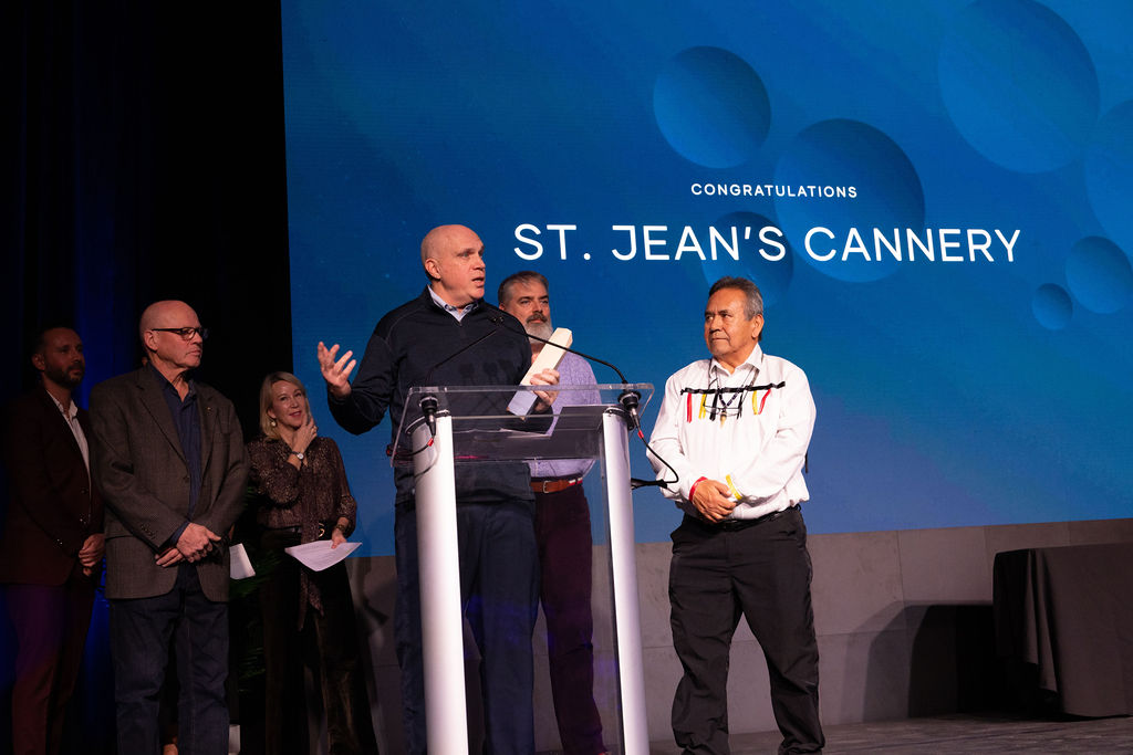 A man standing on a stage at a podium at the 2025 Rise Awards.